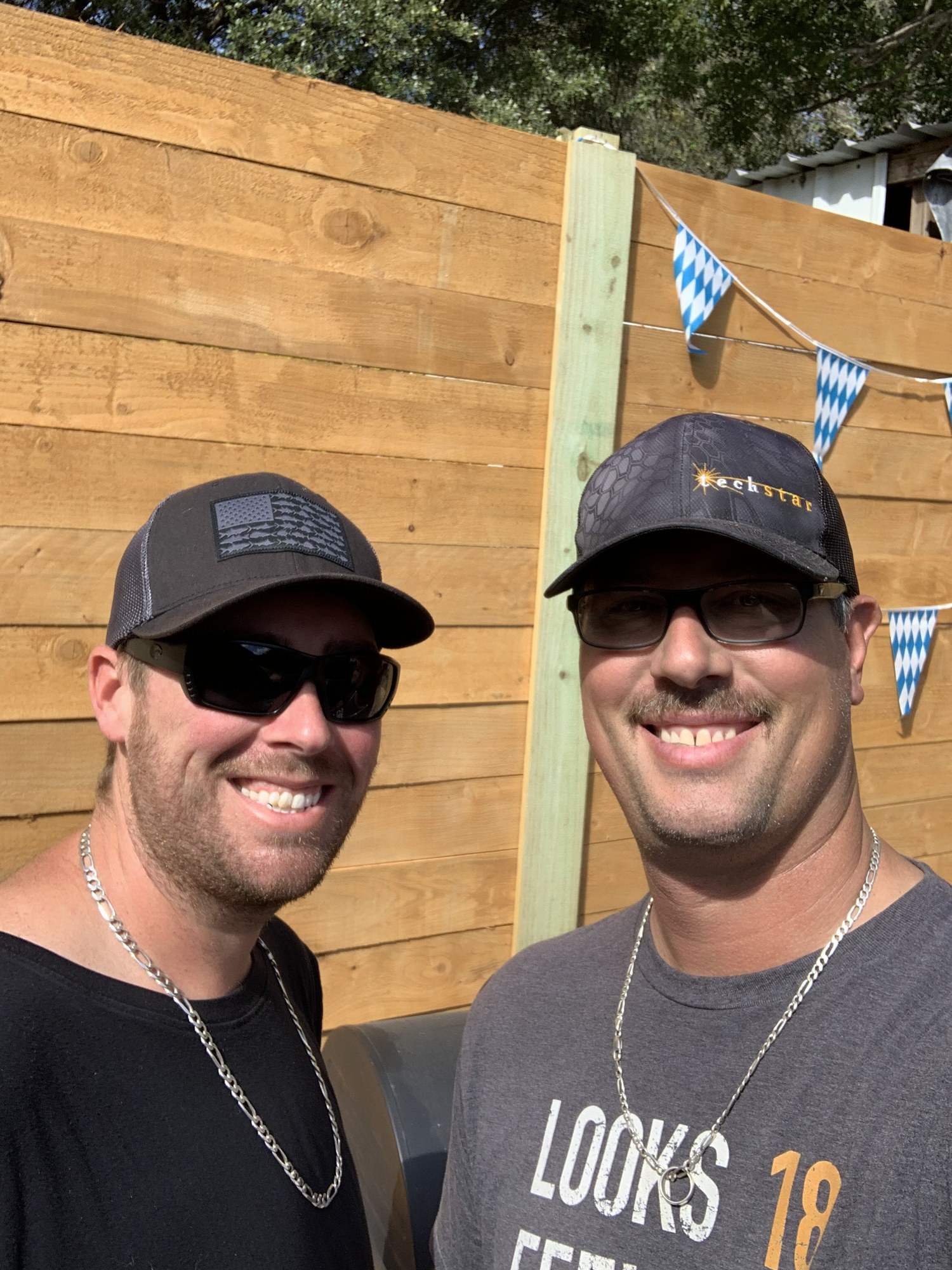 Two friends enjoying Bestfest beneath blue-and-white Bavarian bunting